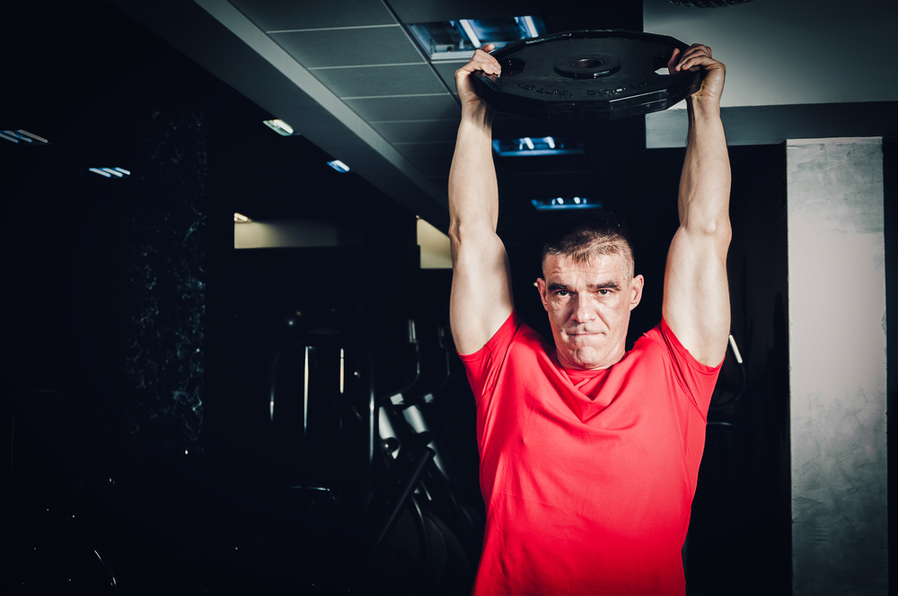 Fitness,Man,Workout,With,Barbell,Weight,Plate,In,The,Gym